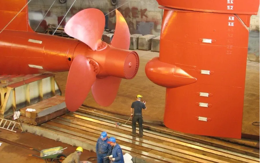 A large ship's propeller and rudder in dry dock